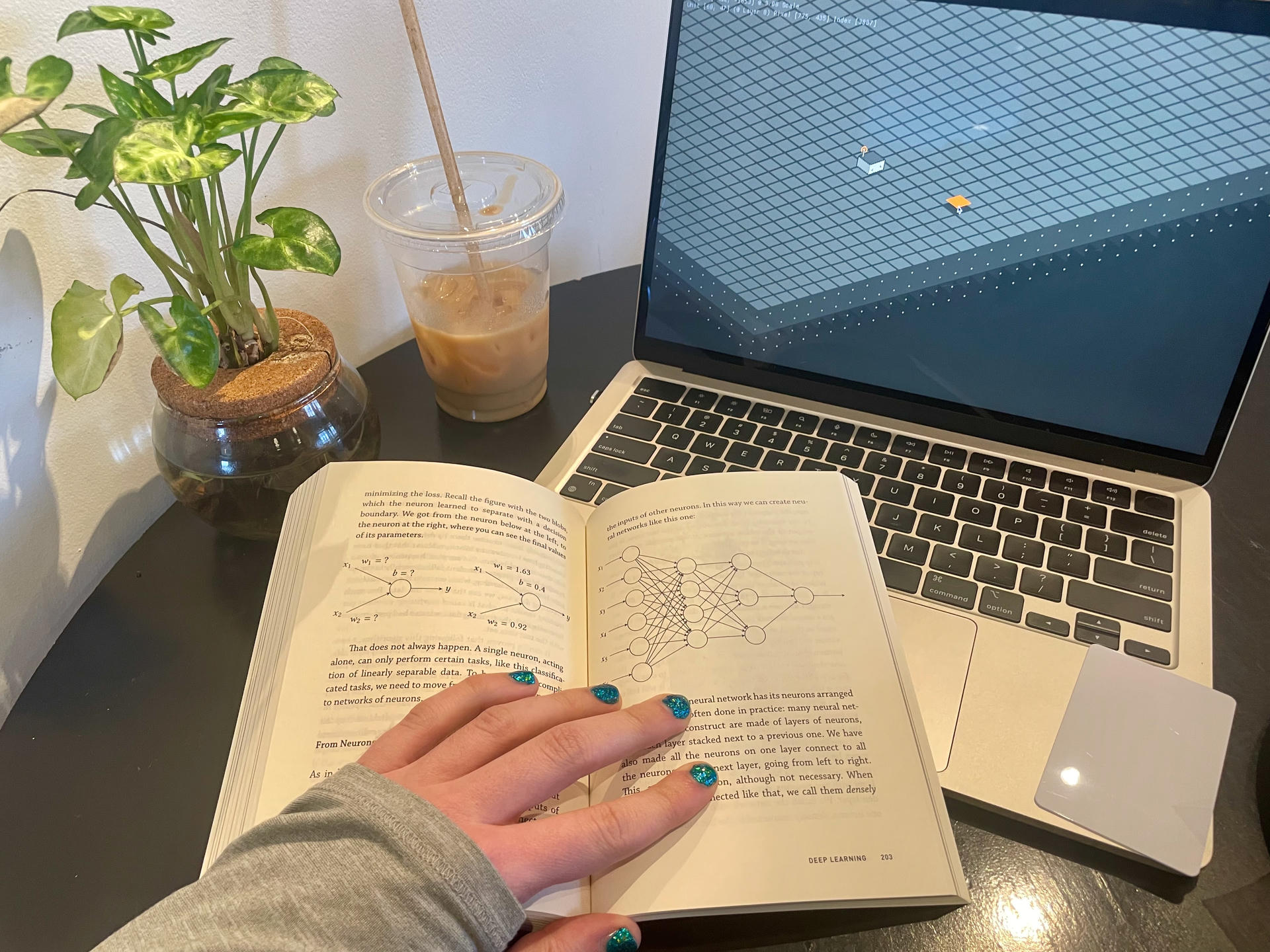 Picture of me sitting with an early 'Layered' prototype and a book on neural networks.